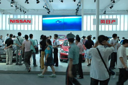 China, Shenzhen Moto - car show in exhibition center. Visitors watching European, American and Chinese cars. Crowd of people interested in newest moto technology.