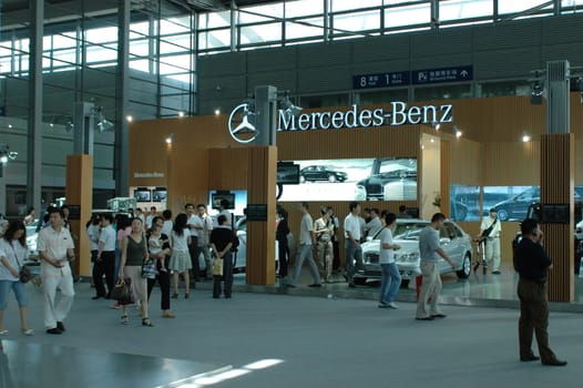 China, Shenzhen Moto - car show in exhibition center. Visitors watching European, American and Chinese cars. Crowd of people interested in newest moto technology.