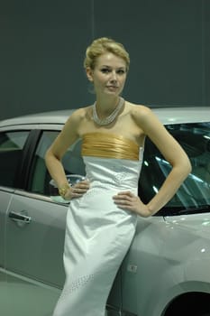 Young, pretty model. Girl promoting modern cars during Shenzhen Moto - car show in China.