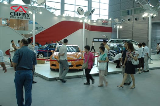 China, Shenzhen Moto - car show in exhibition center. Visitors watching European, American and Chinese cars. Crowd of people interested in newest moto technology.