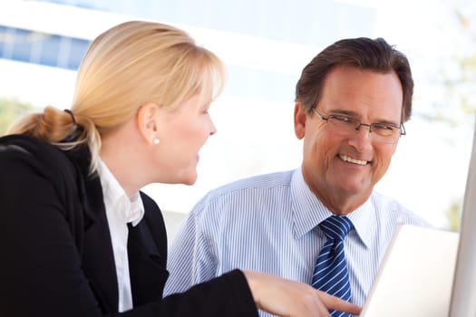 Handsome Businessman Working on the Laptop with Attractive Female Colleague Outdoors.