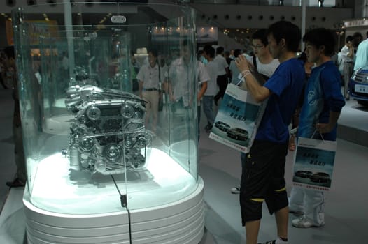 China, Shenzhen Moto - car show in exhibition center. Visitors watching European, American and Chinese cars. Crowd of people interested in newest moto technology.