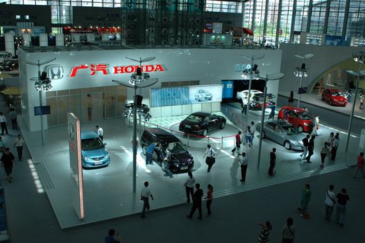 China, Shenzhen Moto - car show in exhibition center. Visitors watching European, American and Chinese cars. Crowd of people interested in newest moto technology.