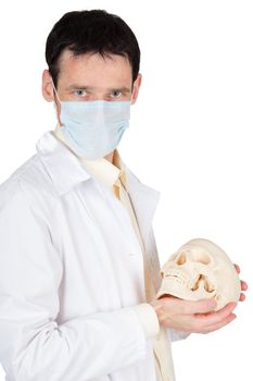 Young doctor in a medical mask with a skull in his hands