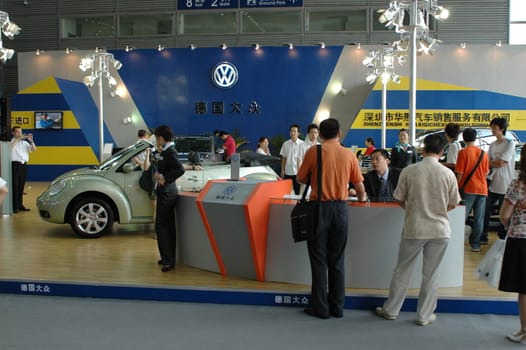 China, Shenzhen Moto - car show in exhibition center. Visitors watching European, American and Chinese cars. Crowd of people interested in newest moto technology.