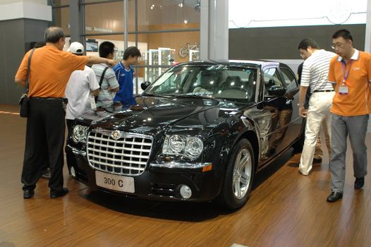 China, Shenzhen Moto - car show in exhibition center. Visitors watching European, American and Chinese cars. Crowd of people interested in newest moto technology.