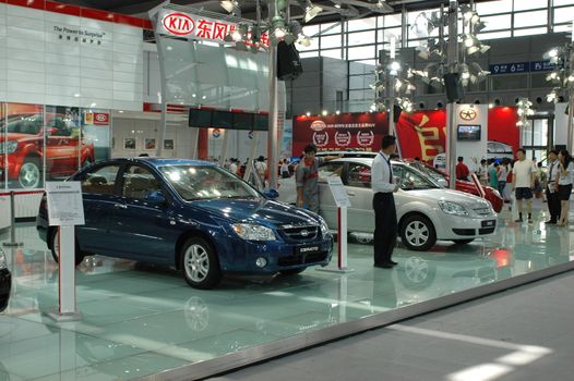 China, Shenzhen Moto - car show in exhibition center. Visitors watching European, American and Chinese cars. Crowd of people interested in newest moto technology.