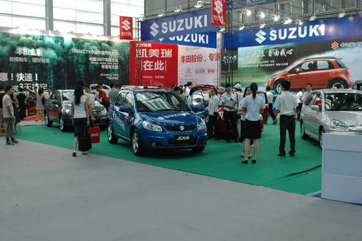 China, Shenzhen Moto - car show in exhibition center. Visitors watching European, American and Chinese cars. Crowd of people interested in newest moto technology.