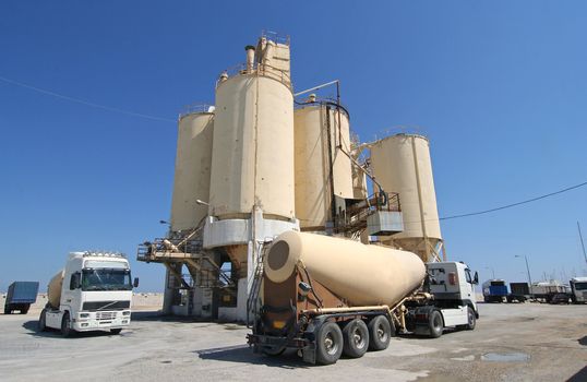 Cement factory with silos and trucks