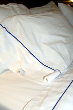 A hotel bed with clean, white linens