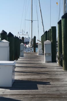 A wooden pier with pylons and a boat at the end.