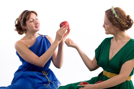 Two ladies in antique dress and apples on white background
