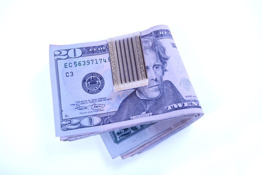 Dollar bills in money clipn with twenty dollar bill on top