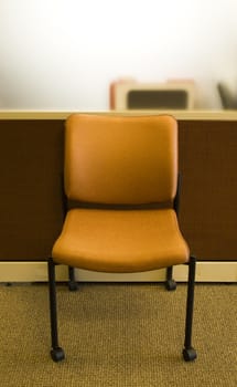modern orange office chair against a cubicle
