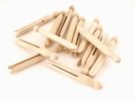 A pile of old fashioned clothespins isolated on a white background.