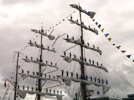 sailors standing in sails on tall ships race