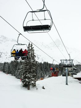 Chairlift with skiers at Meribel ski resort, France