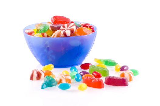 Blue bowl with different kinds of colorful candy isolated on white.