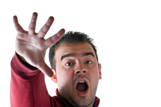 A young man holding his hand up in fear or shock.  Shallow depth of field with focus on the face.