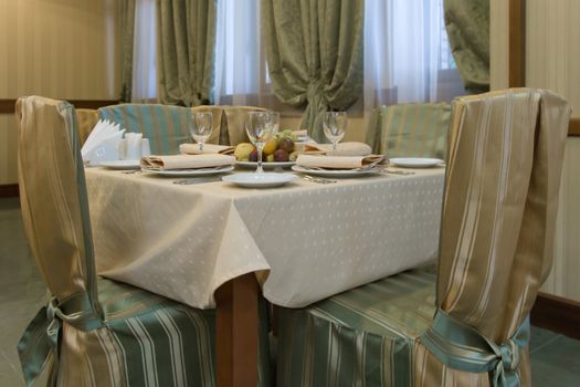 Table with chairs prepared for dinner in restaurant