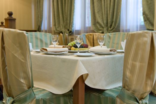 Table with chairs prepared for dinner in restaurant