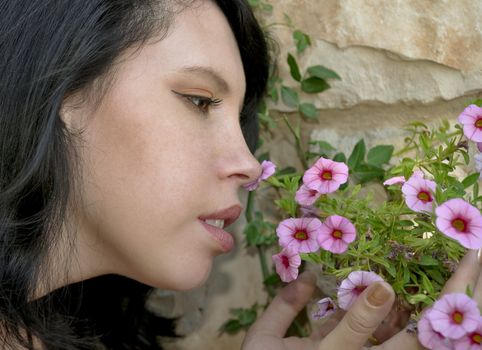 Portrait of a girl with flowers on a background of a stone wall.