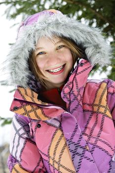 Portrait of happy teenage girl in winter ski coat with fur hood