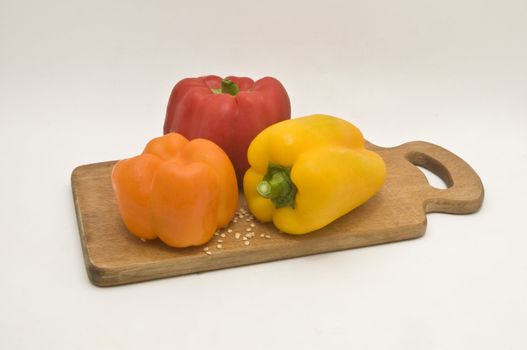 Still life. Three Bulgarian pepper on a wooden kitchen blackboard