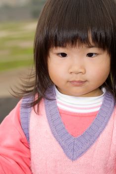 Cute Asian baby portrait with quiet expression in outdoor.
