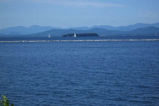 Mountains, blue waters, and sailboats of Vermont Lake