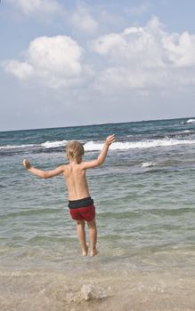 holidays, the boy is playing on the beach, swimming, jumping into the sea