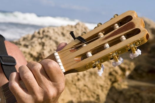 guitar neck against the backdrop of the sea