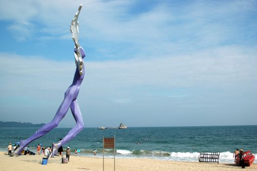 China South Sea, Guangdong province. Shenzhen city - sea side, wide beach at DaMeiSha. Large angels sculptures standing at the beach.