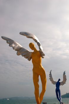 China South Sea, Guangdong province. Shenzhen city - sea side, wide beach at DaMeiSha. Large angels sculptures standing at the beach.
