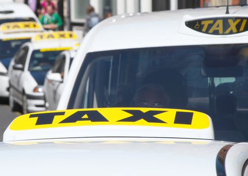 Telephoto view of taxi cabs in busy city street