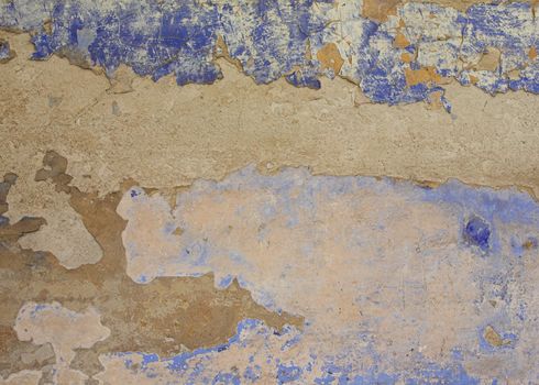 Surface of a crumbling painted blue wall.