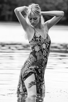 Young blond woman wearing a dress in the forest