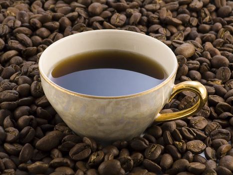 coffee cup full of coffee beans on dark background