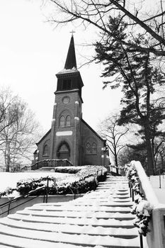 This old church sits on a hill and is blaneted by winter snow.