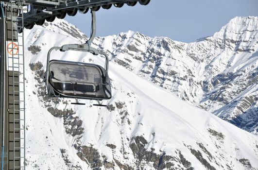 Chairlift with impressive mountains in the background - shot in Livigno, Italian Alps