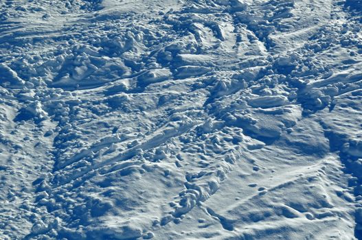 Tracks of skiers and snowboarders in powder snow