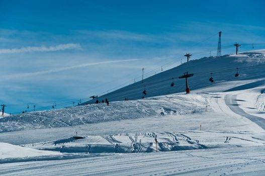 Pretty empty ski piste with chairlifts in the background - shot in Livigno, Italian Alps