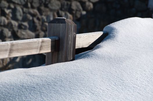 Closeup of fence covered by huge amounts on new powder snow