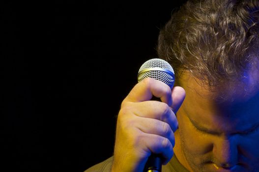 Passionate Vocalist with Microphone on a black background.