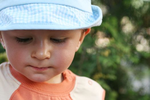 Little thinking boy with blue cap