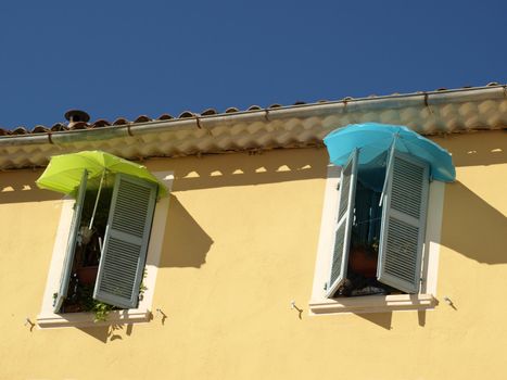 colored umbrellas to protect from sun in a french provence street