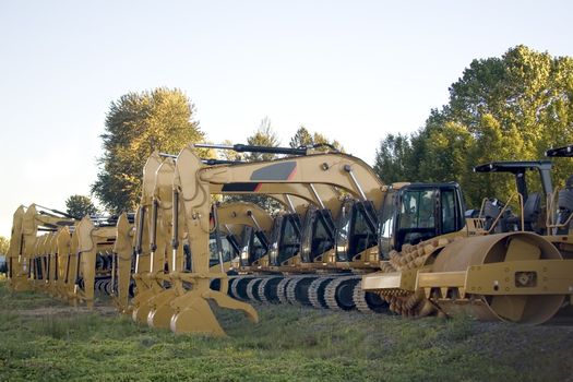 New steamrollers, bulldozers and front-end loaders in a row on the sales lot.