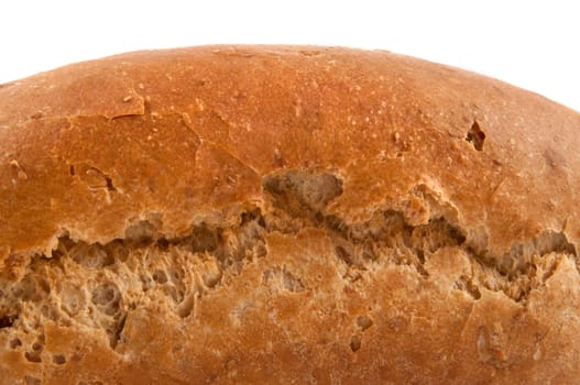 Close, low level focussing on the side of a fresh, crusty wholemeal loaf of bread with white background.
