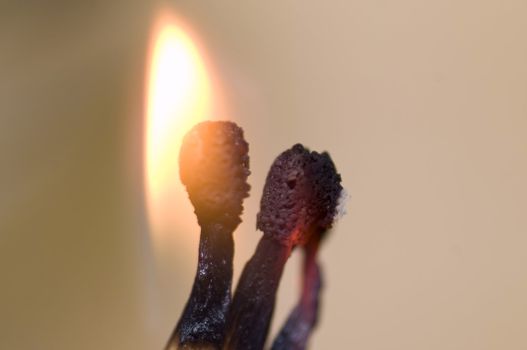 macro on burning matches on light wood background