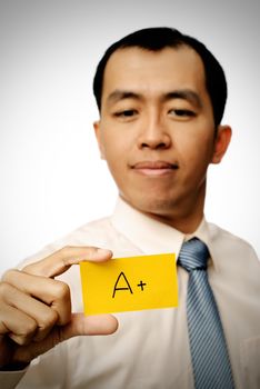 Successful businessman holding A+ card in yellow color.